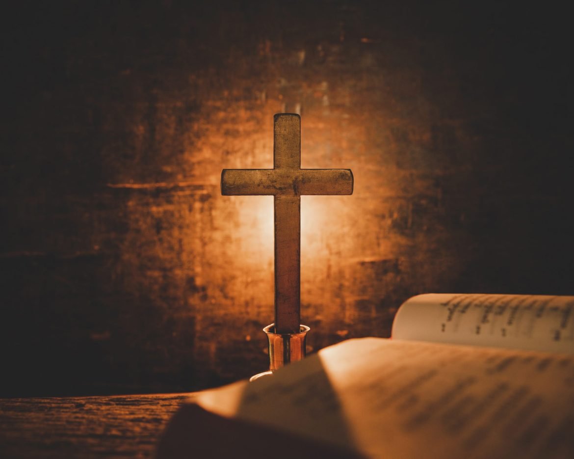 Open Holy Bible and candle on a old oak wooden table. Beautiful